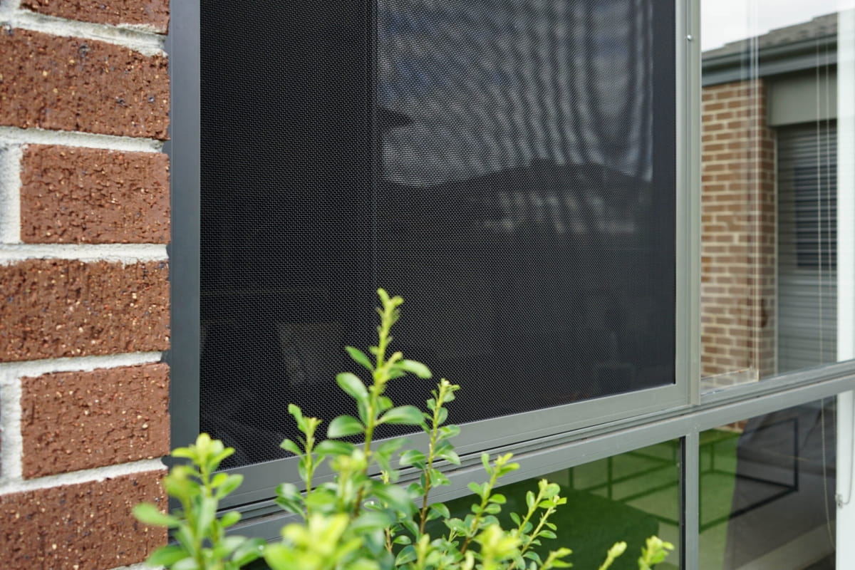Exterior view of a home window fitted with a strong security screen to help prevent falls through open windows.