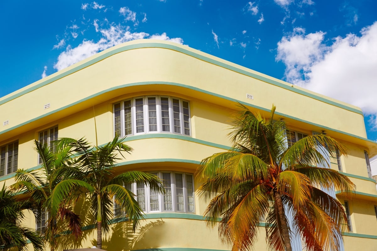 Art Deco buildings painted yellow with palm trees.