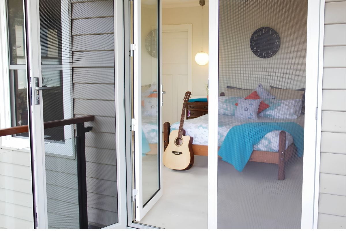 Safety Screen Door or Security Door? Don’t Risk the Wrong Choice 4 White-framed security door fitted across a wide balcony entrance.