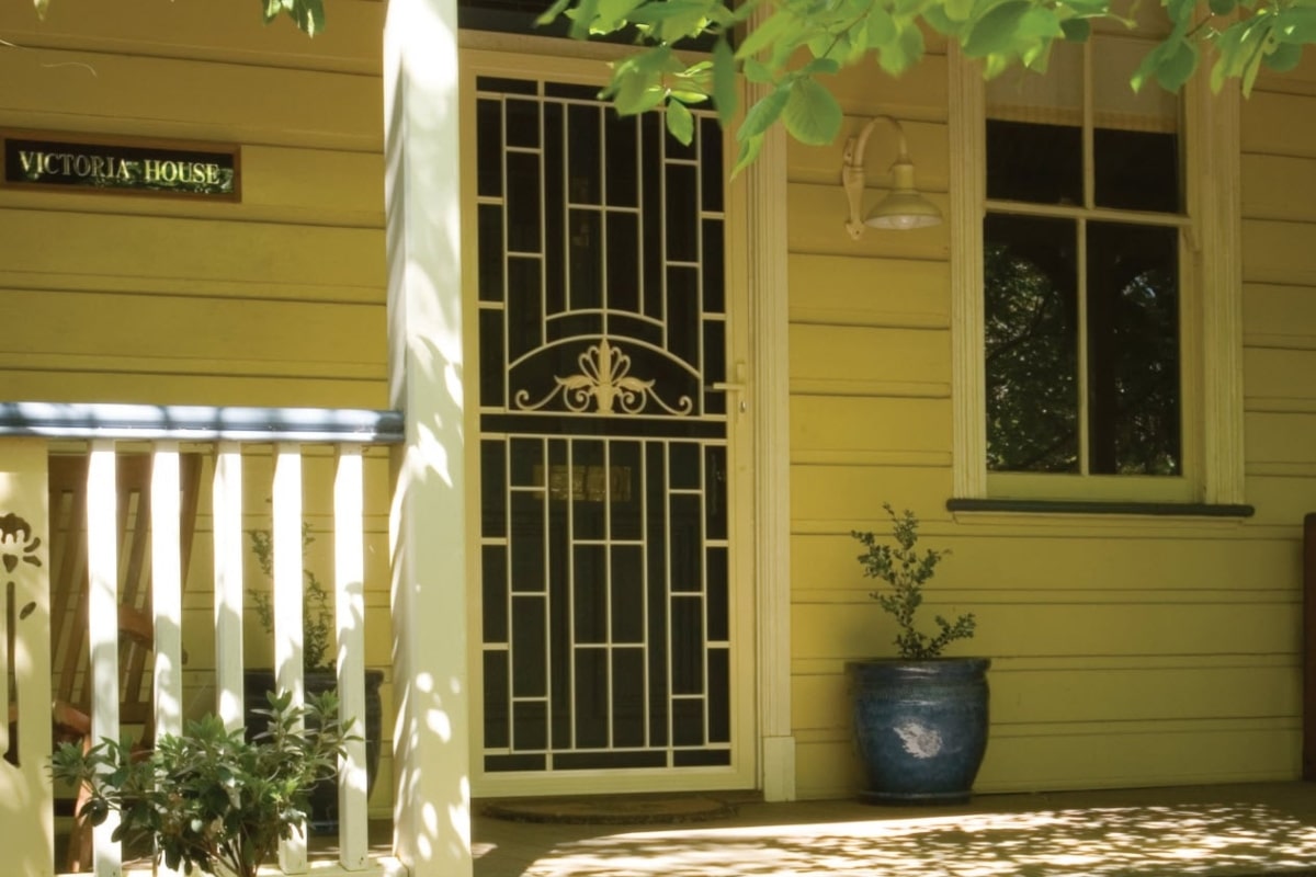A home with a decorative, heritage style screen door.