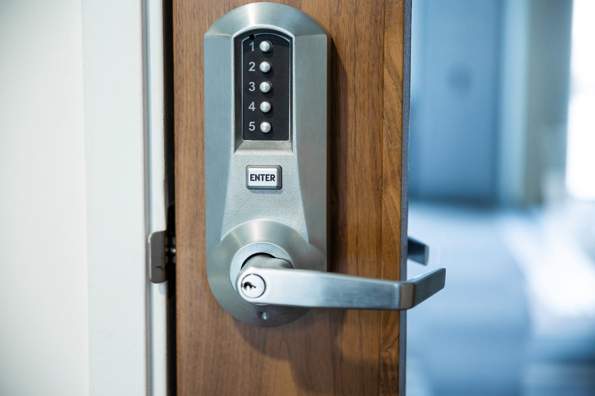 A digital lock with a pin code keypad is securely mounted on a wooden door, showcasing the blend of traditional aesthetics with modern security technology.