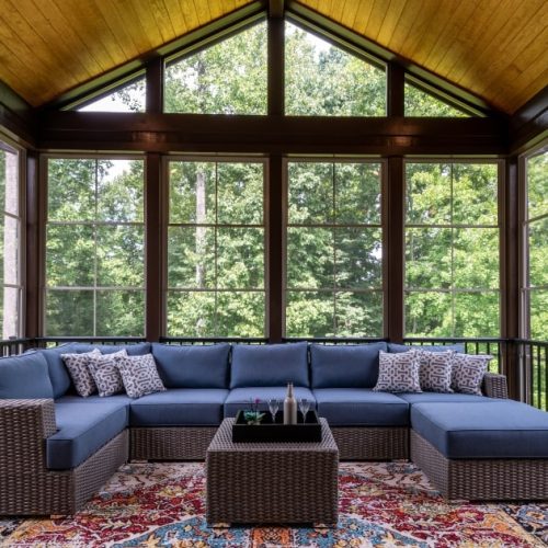 Enclosed patio with screen walls, high ceiling and forest view.