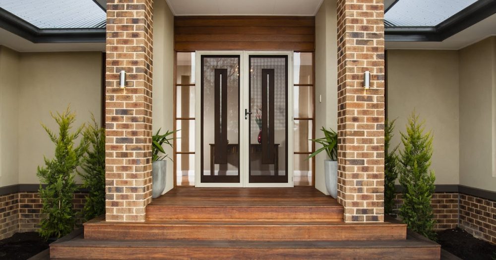 Beautiful home using stone and unique hinged front doors to create kerb appeal.