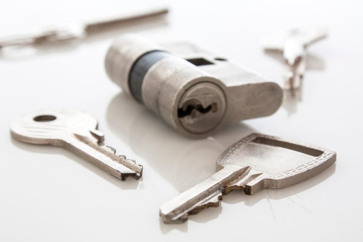 A lock cylinder and four silver keys.