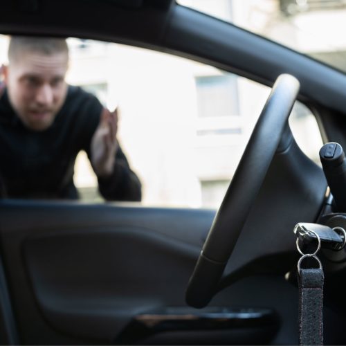 Man locked out of car with car keys hanging in ignition.