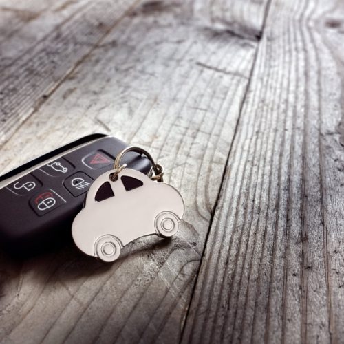 Car key proximity remote sitting on wooden table.