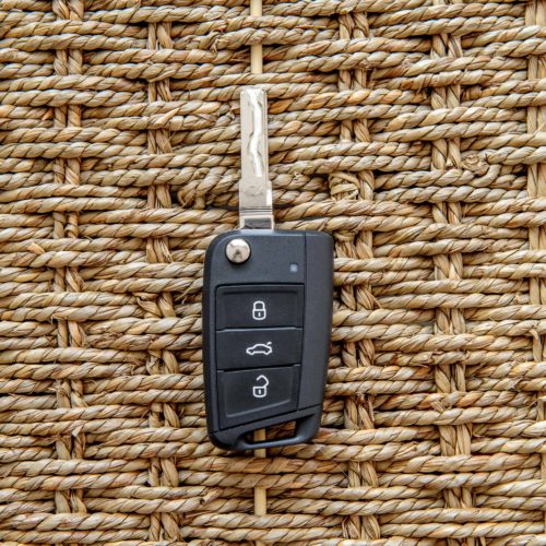 Car key transponder sitting on woven wooden box.