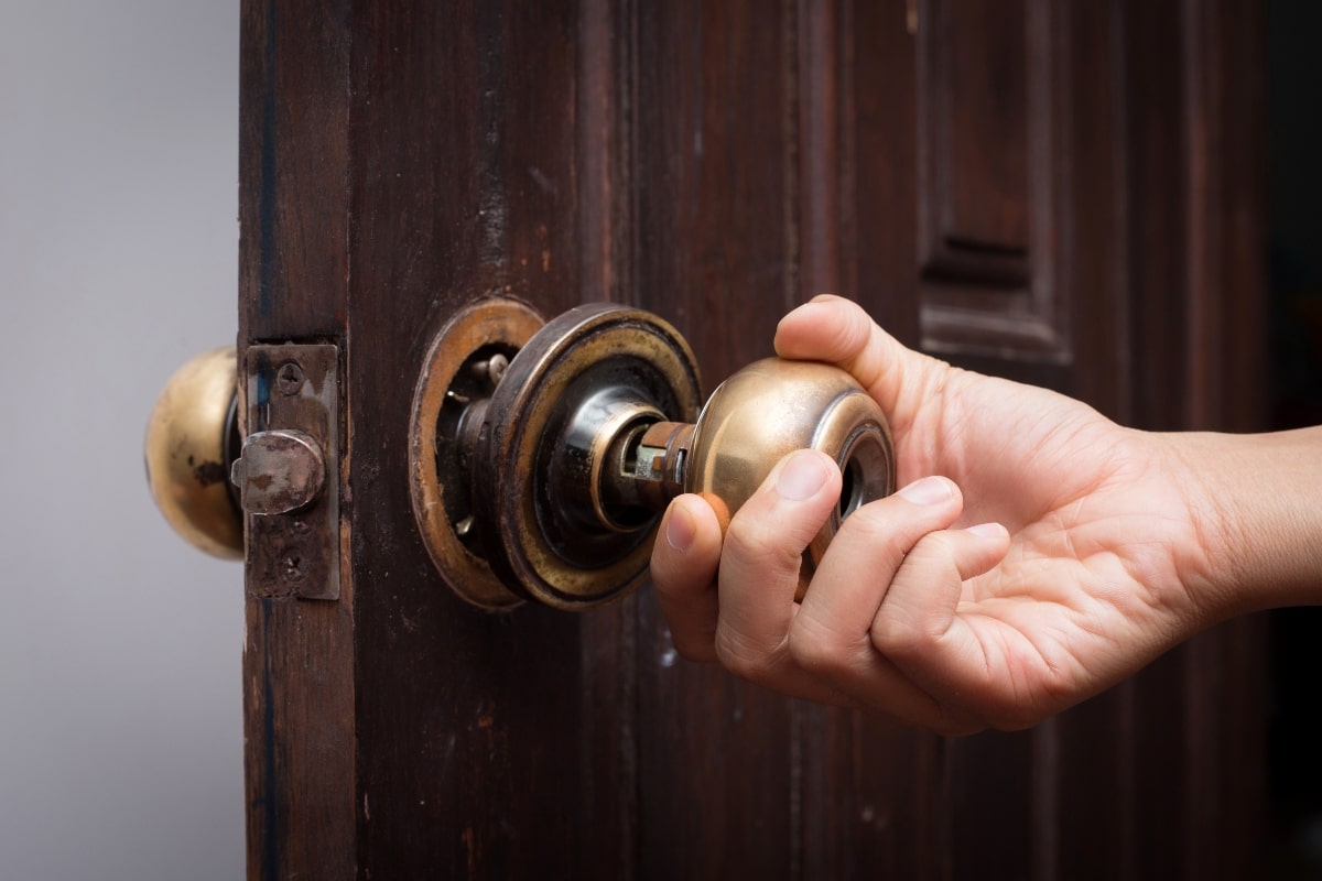 Loose door lock and knob on wooden door.