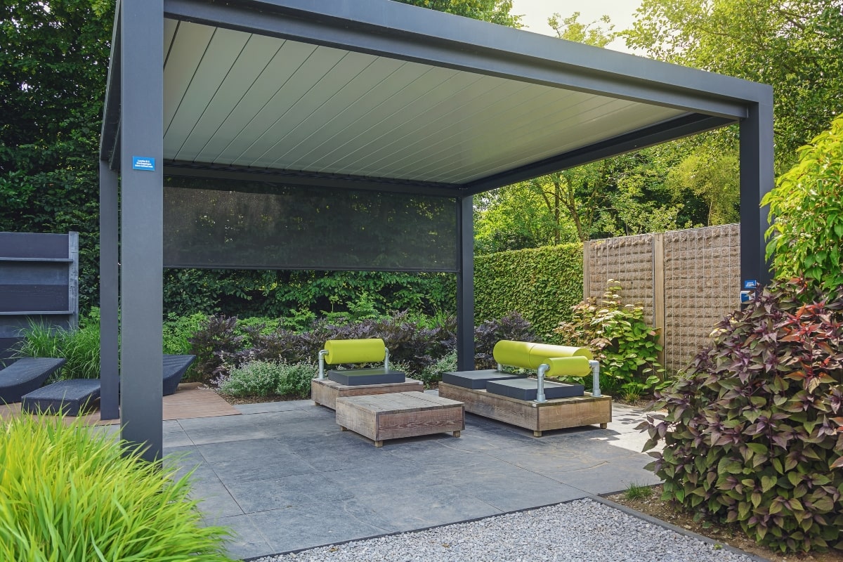 Freestanding patio enclosure with outdoor blinds and stylish furniture.