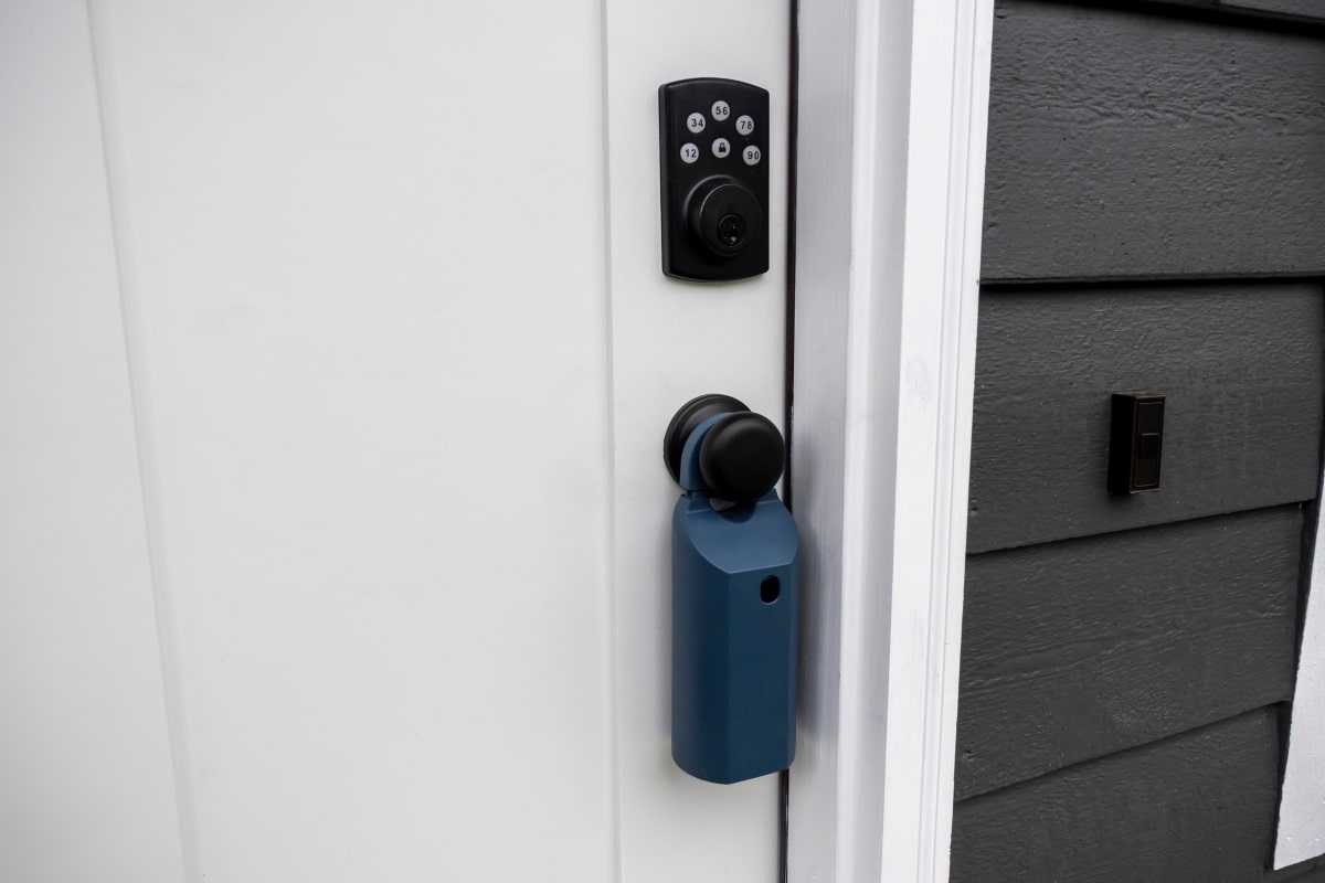 A smart door lock with a numbered pin pad is prominently featured on a residential door, highlighting the secure, keyless entry benefits for short-term rental properties.