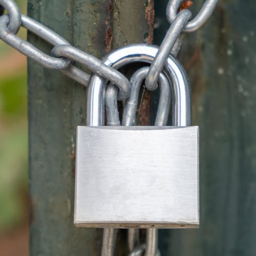 Property lock types padlock on gate.