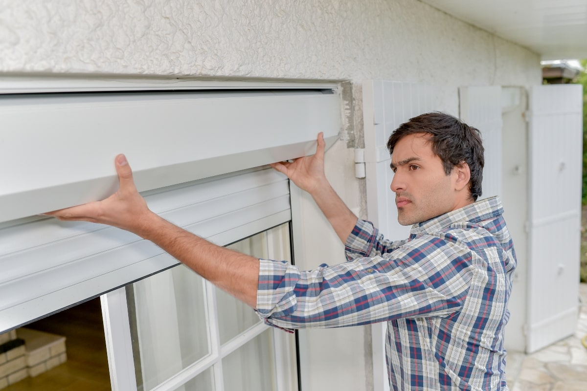 Man conducting regular inspection of roller shutters .