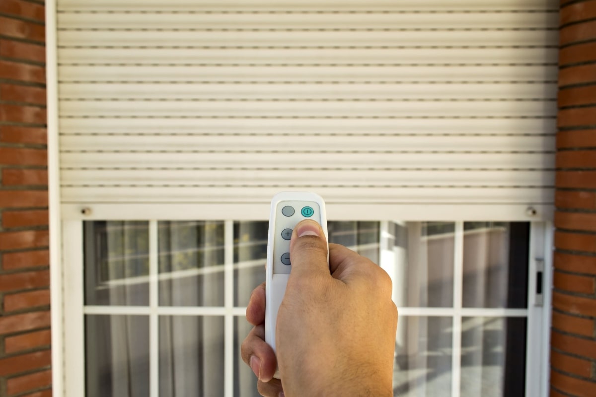 A close-up of a remote being used to operate a roller shutter.