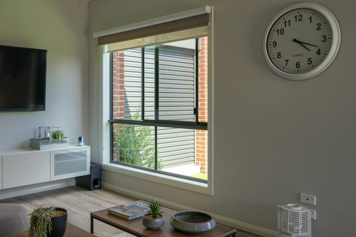 Living room window fitted with a security screen to help reduce the risk of window falls while maintaining airflow and visibility.
