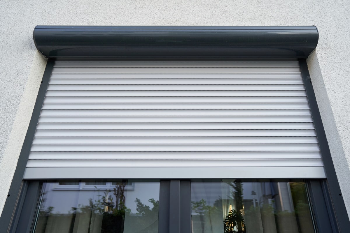 Exterior view of a modern window fitted with a rolled-down shutter.