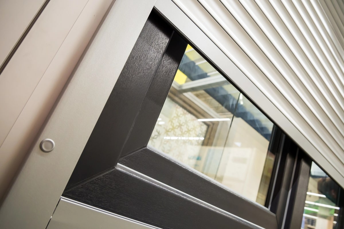 Close-up of a modern window with a partially closed roller shutter.